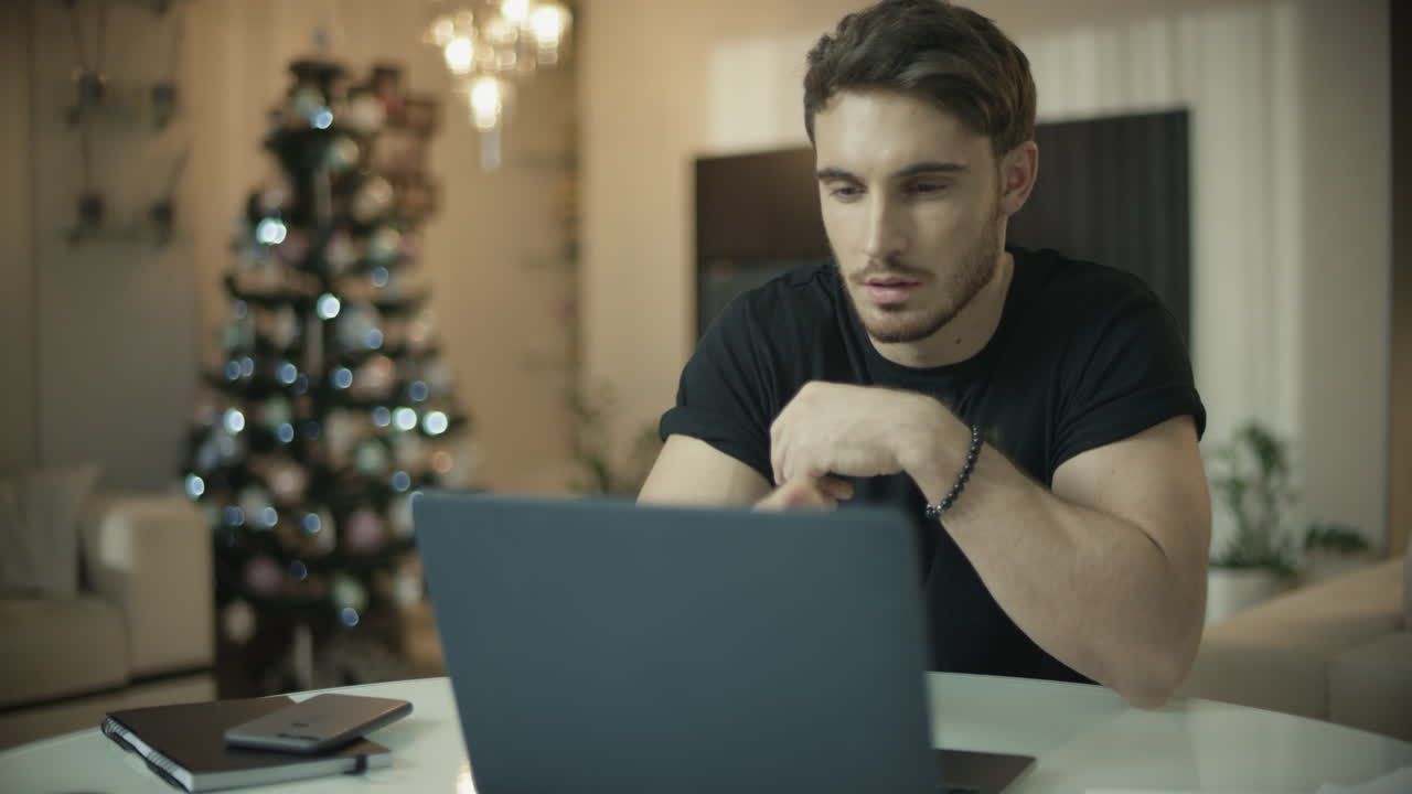 Uomo che usa il laptop vicino all'albero di Natale. Uomo d'affari casual che fa acquisti online.