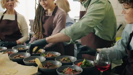 group of people preparing food in a kitchen