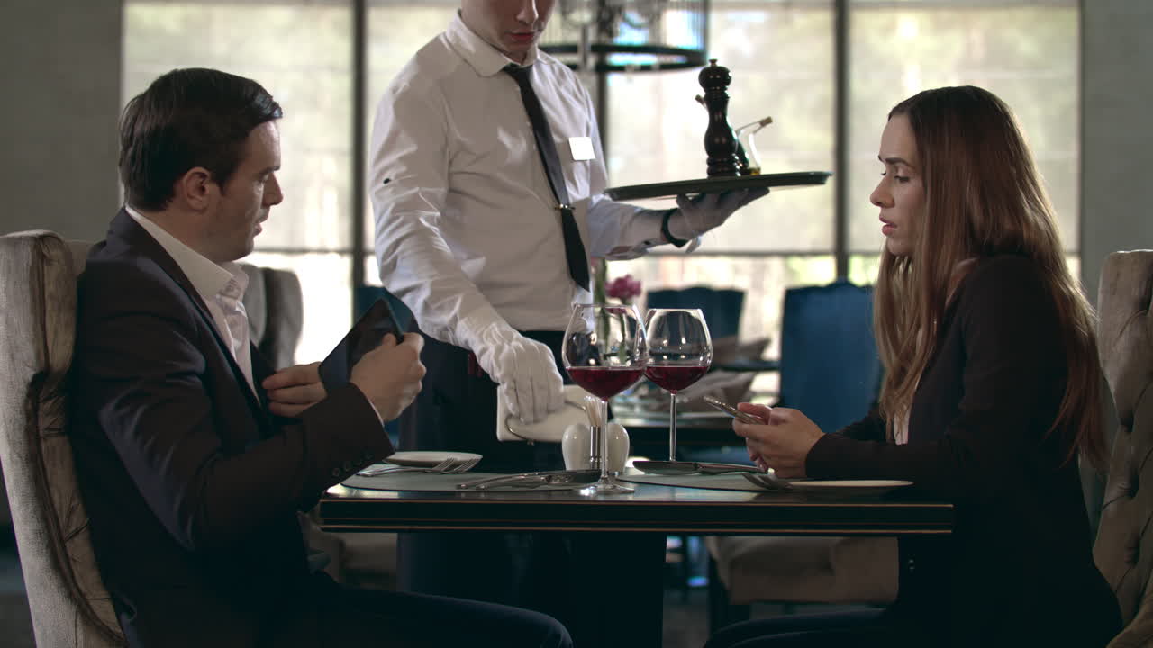 레스토랑에서 행복한 커플이 만난다. 레스토랑에서 테이블을 제공하는 웨이터