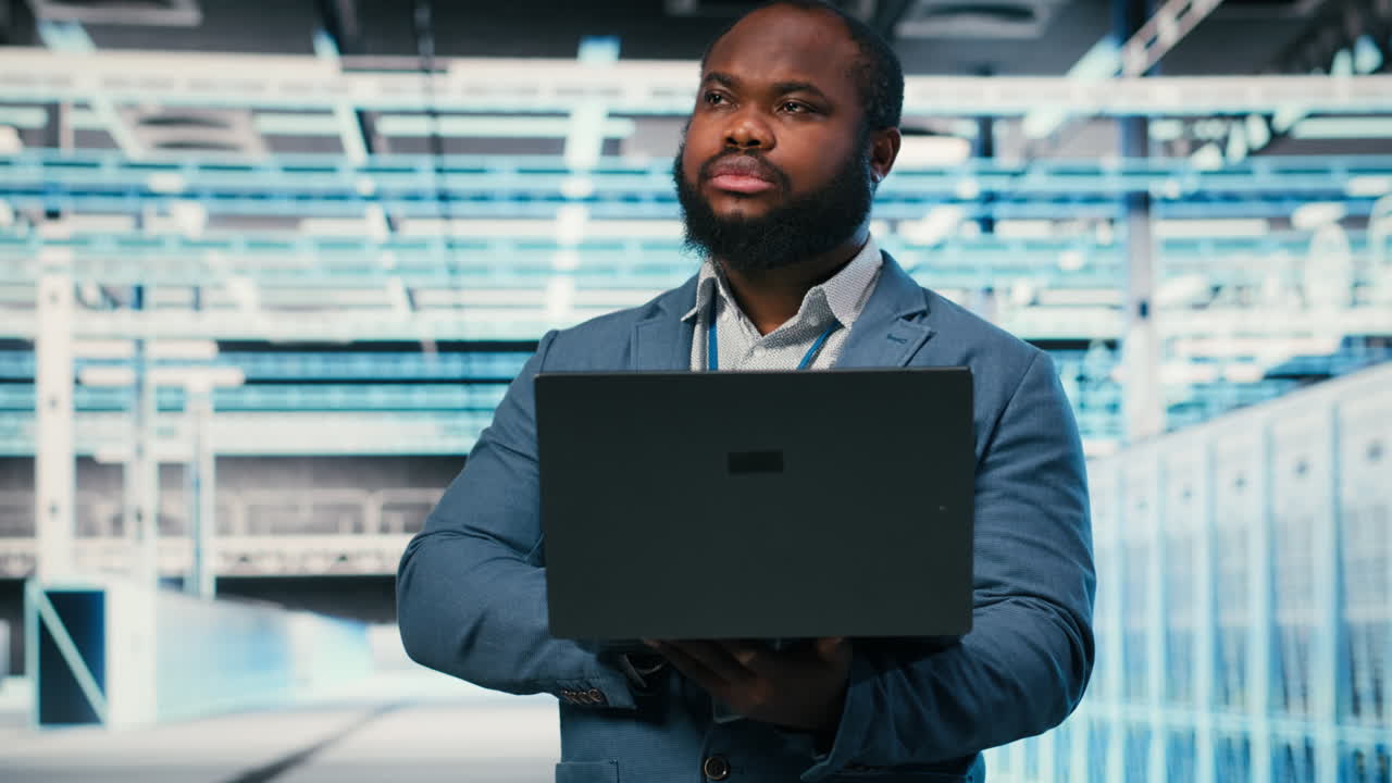 IT Professional Working on Laptop in Modern Data Center