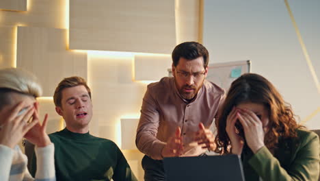boss arguing team meeting after phone call in workspace. colleagues failed deal.