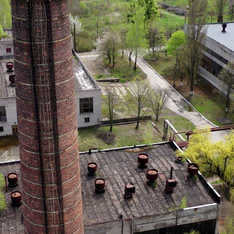 old industrial territory. abandoned buildings of ancient factory. ruined edifices in spring. old brick pipe of industry. aerial view