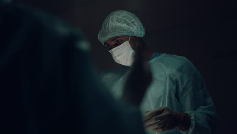 male surgeon in operating room communicating preparing for surgical treatment.