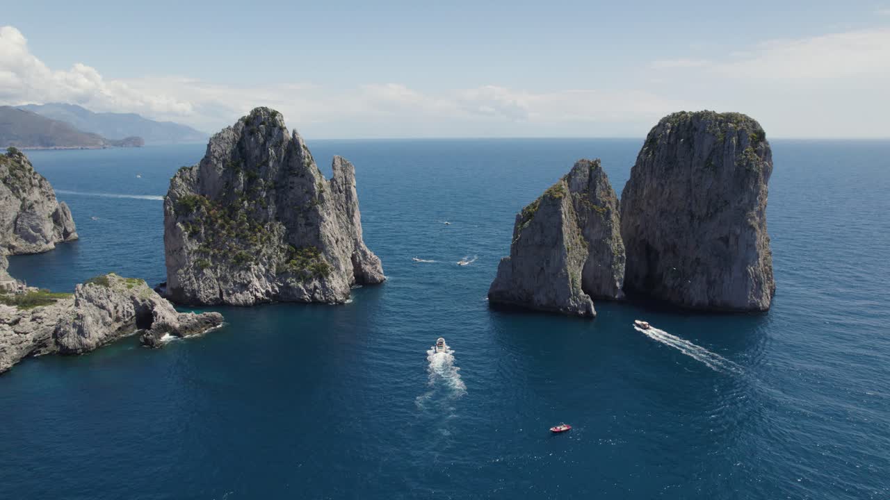 vista aérea de barcos que navegan en el mar con faraglioni formación rocosa en capri, italia