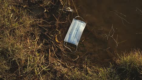 used medical mask in water of lake