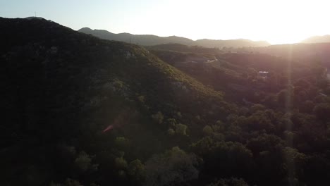 Pocas-Casas-En-Las-Colinas-Rodeadas-De-Mucha-Vegetación-Natural,-Imágenes-Aéreas-De-Drones