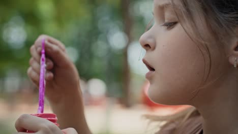 Caucasian-girl-blowing-soap-bubbles-at-the-park.