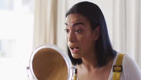 mixed race gender fluid vlogger recording a make up vlog at home