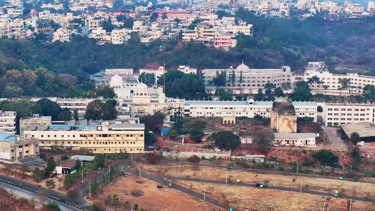 Ospedale Guru Nanak con Gurudwara Sri Nanak Jhira Sahib e edifici residenziali a Bidar, Karnataka, India. Di giorno, inquadratura in allontanamento, ripresa con drone, 4K.