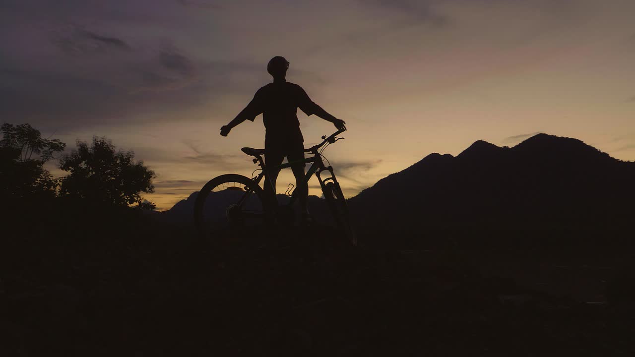 Silhouette of Cyclist at Sunset in the Mountains