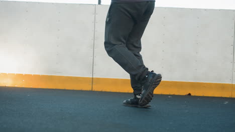 vista trasera de un atleta corriendo en una arena deportiva con enfoque en las piernas y los zapatos, mostrando movimiento dinámico, aptitud y acción contra el límite amarillo y el fondo urbano