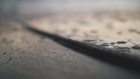 close-up of sea water flowing up and down over a rope on the shoreline making bubbles during golden hour - blurry background