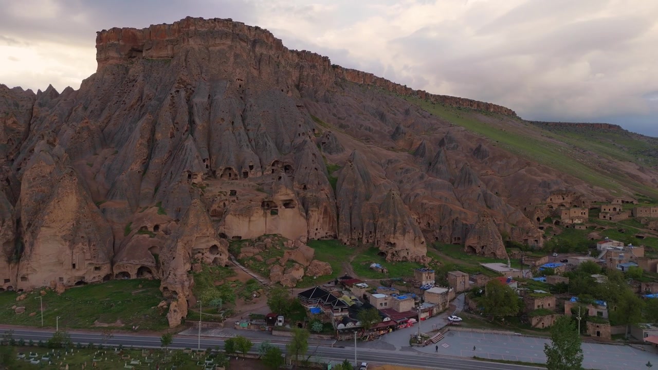 Dik bir dağ sırtına inşa edilmiş Selime Katedrali kaya oyma manastır yapılarının drone görüntüsü. Türkiye'de dramatik jeolojik arazi ve simgesel tarihi mimari