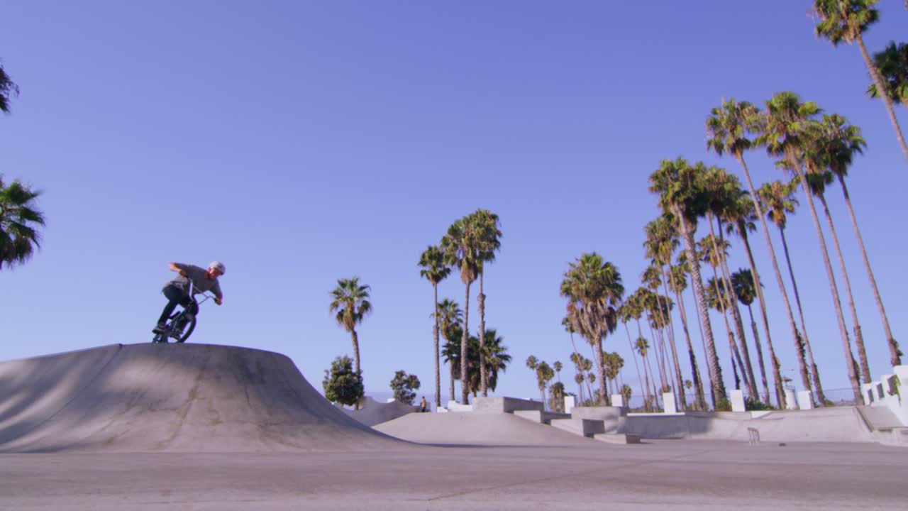 점프를 실행하는 bmx 자전거 라이더의 낮은 각도 보기 및 skatepark에서 회전