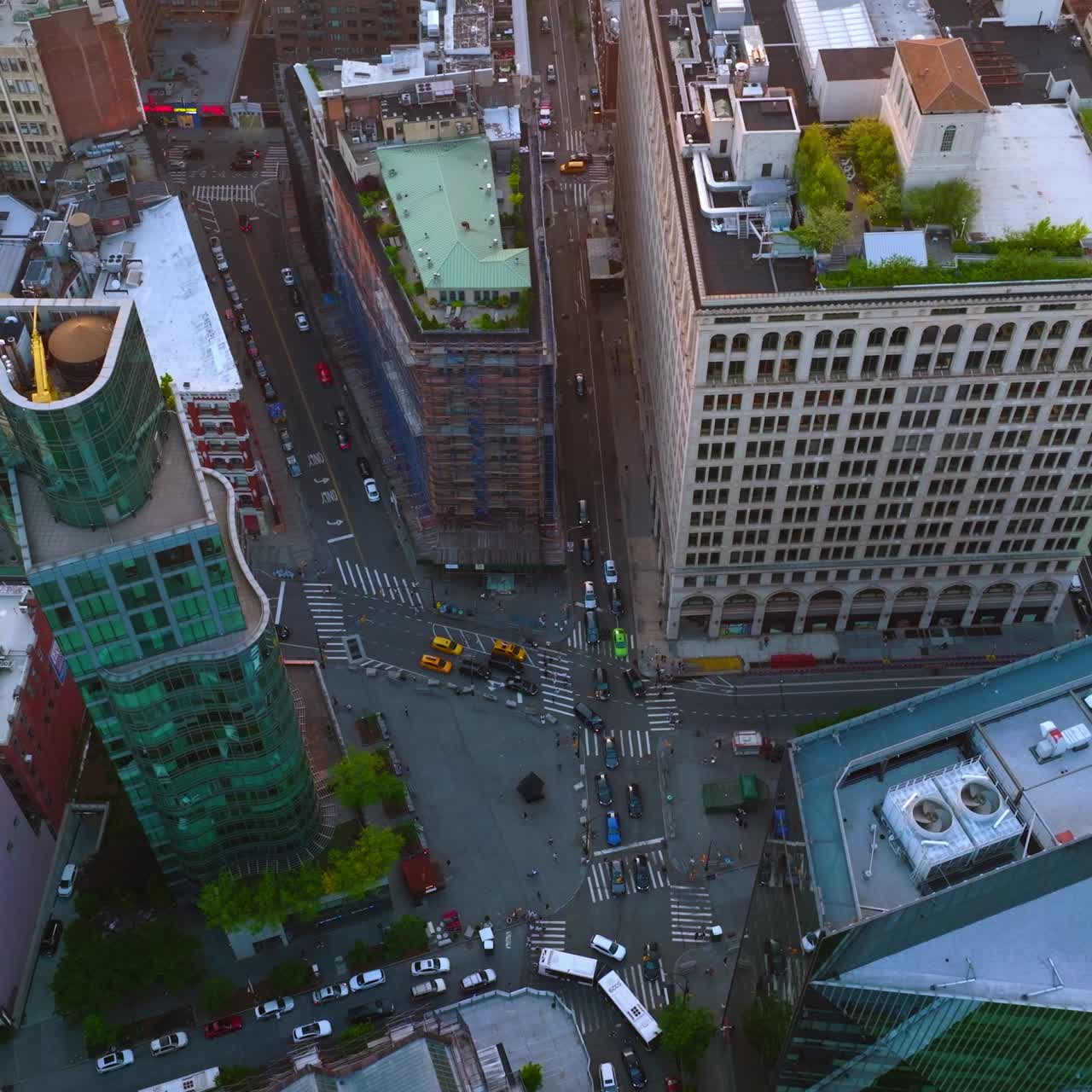Impressive high buildings of New York, USA at daytime. Drone rising over the crossroads of six streets busy with cars. Top view