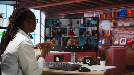 employee greeting coworkers during videocall from home desk