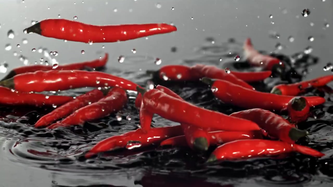 Red Chili Peppers Falling and Splashing into Water