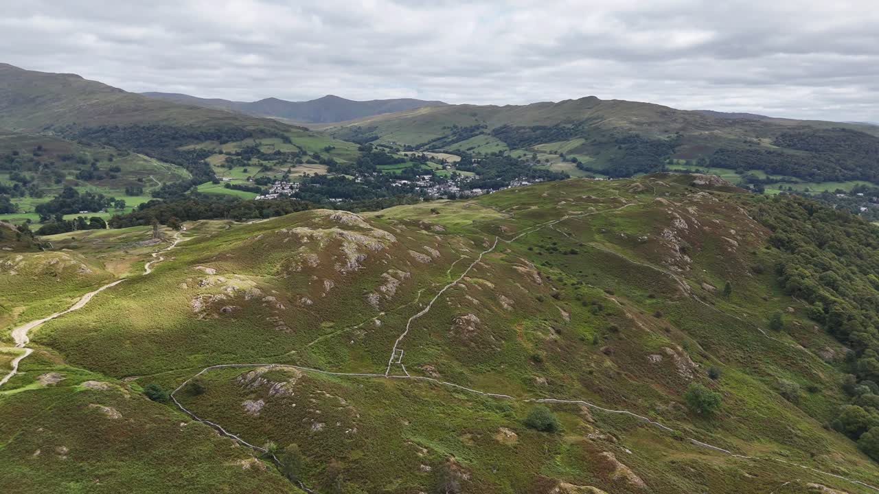 Aerial drone footage capturing sweeping views over Loughrigg Fell in the Lake District on a clear summer’s day