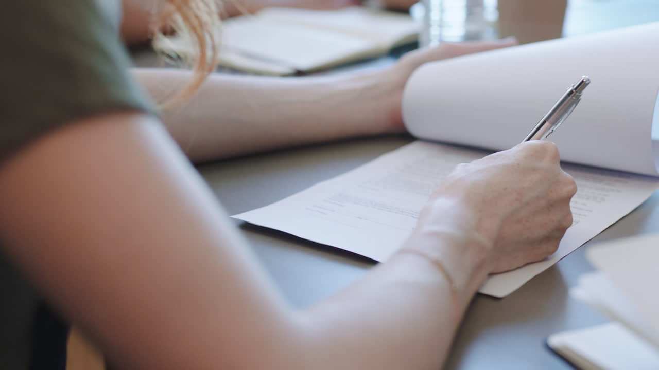 la mano de la mujer de negocios firma el contrato en la reunión