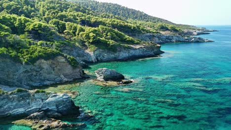 a secluded beach with turquoise water surrounded by rocky cliffs and lush green trees