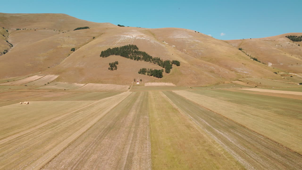 vastos campos campesinos con paisaje montañoso en el fondo en piana grande cerca de castelluccio di norcia, toscana italia