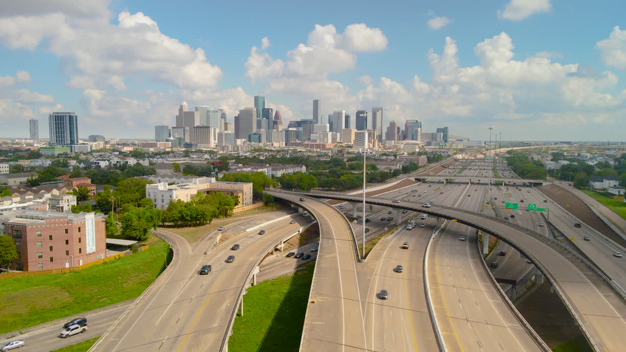 Establishing drone shot of Downtown Houston from Texas 288 Freeway. Revealing aerial shot downtown Houston with high skyscrapers. Intro video of Houston. Downtown transportation in sunny day