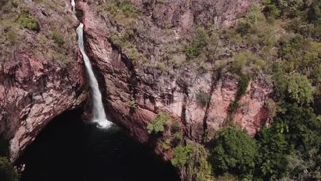 Volando-Sobre-Una-Cascada-Alta-Desde-El-Acantilado-Rocoso-Hacia-El-Desfiladero