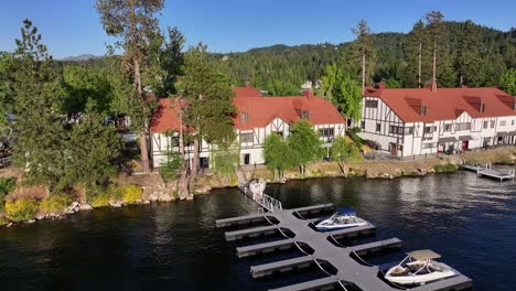 lake arrowhead village waterfront with german styled buildings at sunset and boats docked up aerial pullback raise