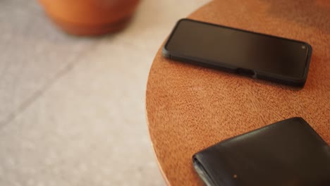 phone, wallet, and credit card on a wooden table