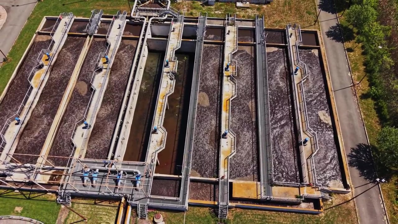Workers operate machinery at a wastewater treatment plant