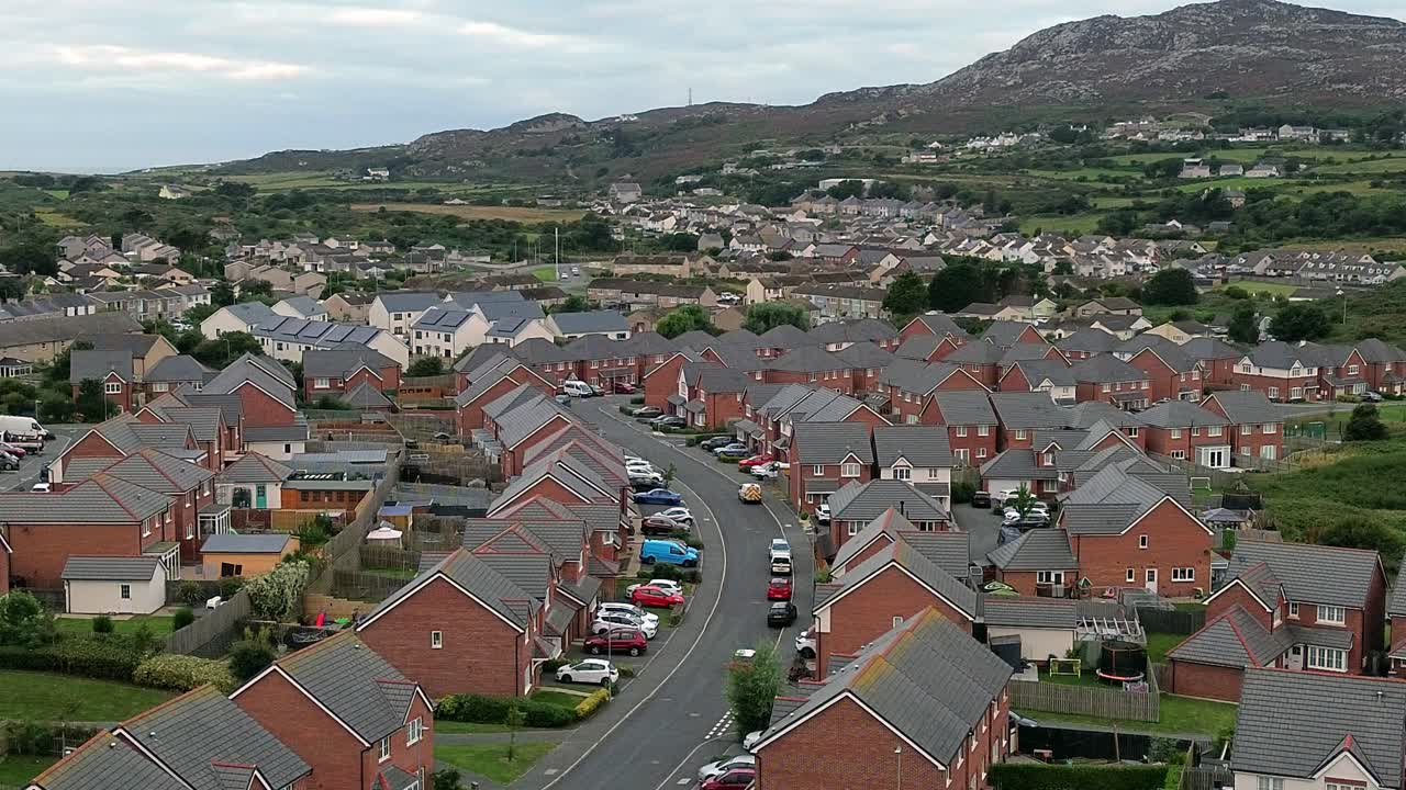 Welsh townhouse modern property aerial view flying across rocky mountain neighbourhood