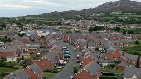 Welsh townhouse modern property aerial view flying across rocky mountain neighbourhood