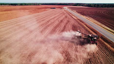 drone view of combine harvester transferring non-gmo soybeans to another trailer tractor