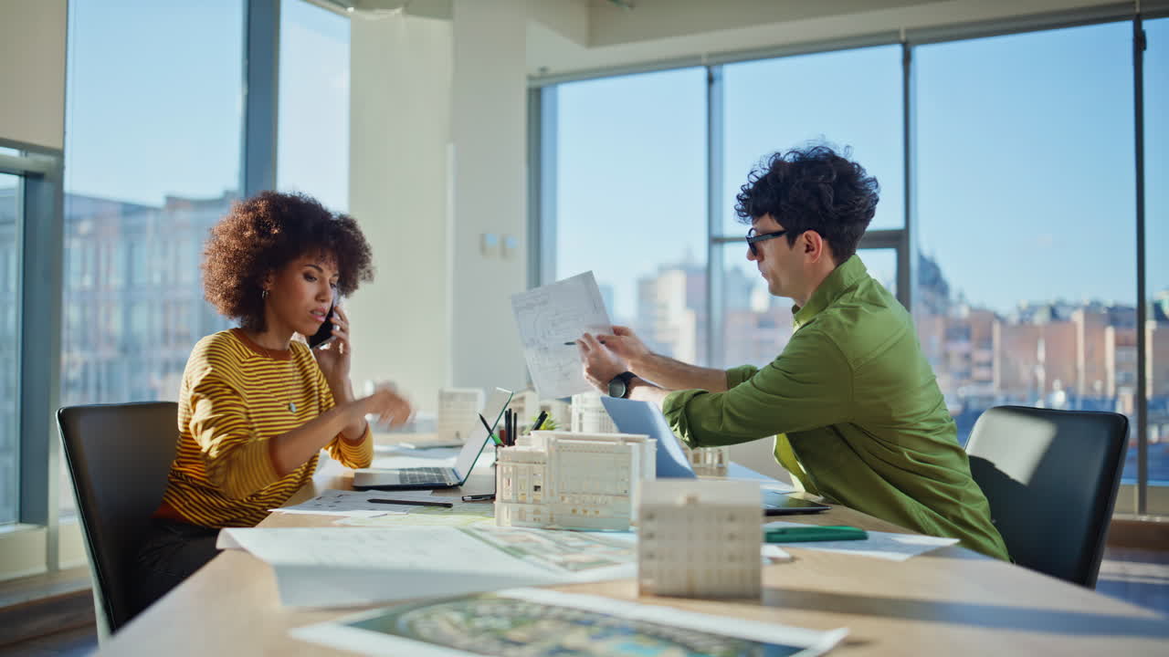 businesswoman talking cellphone taking document from colleague in office