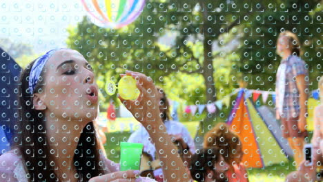 blowing bubbles at outdoor festival, woman surrounded by colorful tents and balloons