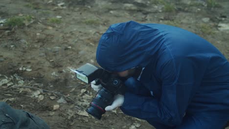 Criminal-investigator-taking-photos-of-crime-scene,-high-angle-closeup