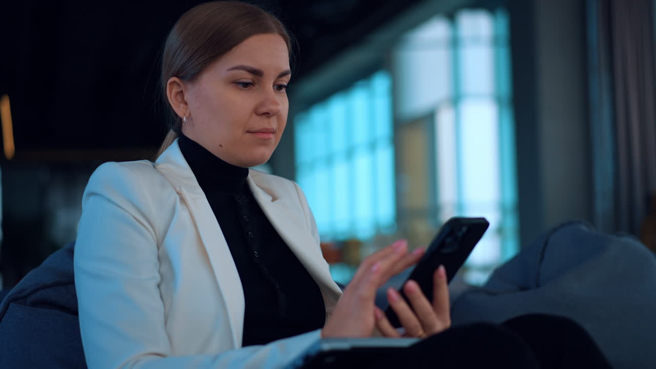 Businesswoman using a smartphone in a modern office setting