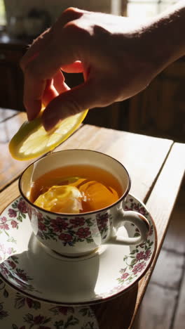 squeezing lemon into tea