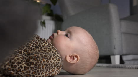 Young-blue-eyed-baby-girl-on-floor,-close-shot