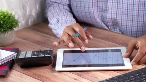 hombre de negocios trabajando en una tableta con gráficos y gráficos