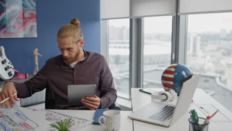 Inspired-architect-watching-sketches-at-home-closeup.-Serious-man-holding-tablet