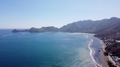 Scenic-aerial-view-of-scenic-coastline-and-ocean-with-Cristo-Rei-statue-in-capital-city-of-Dili,-Timor-Leste,-Southeast-Asia