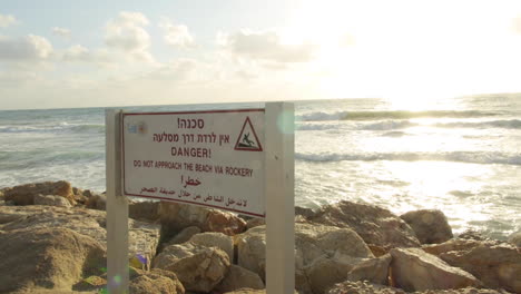 israel shore at sunny happy hour, waves crash on rocks