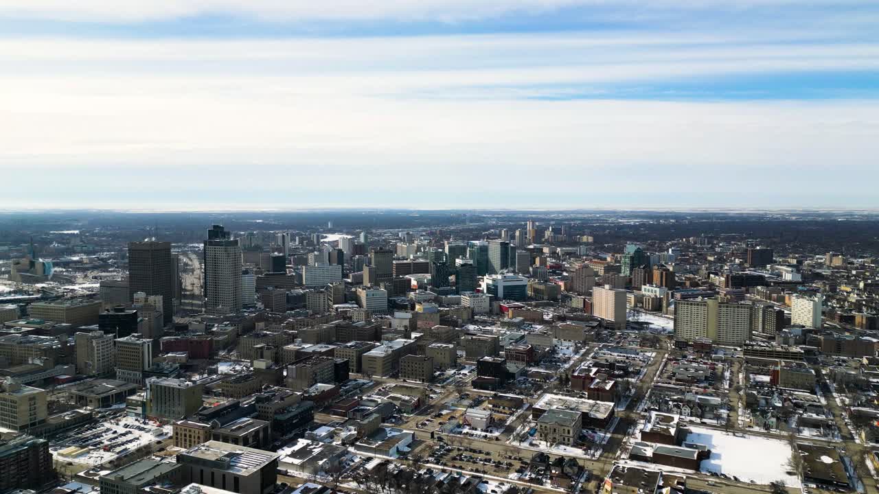 Ripresa aerea introduttiva con drone del centro di Winnipeg, Manitoba, in una luminosa mattina d'inverno con cieli azzurri e sereni.