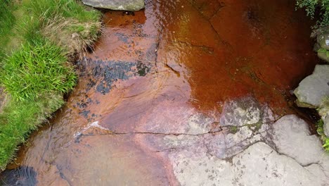 meandering moorland stream in the derbyshire peak district with water flowing over small and large rocks