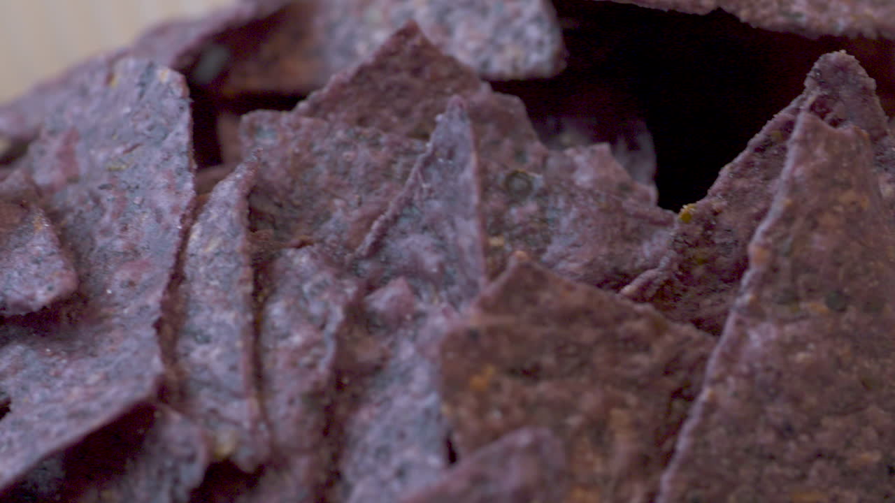 Close up across a bowl of blue corn nacho chips