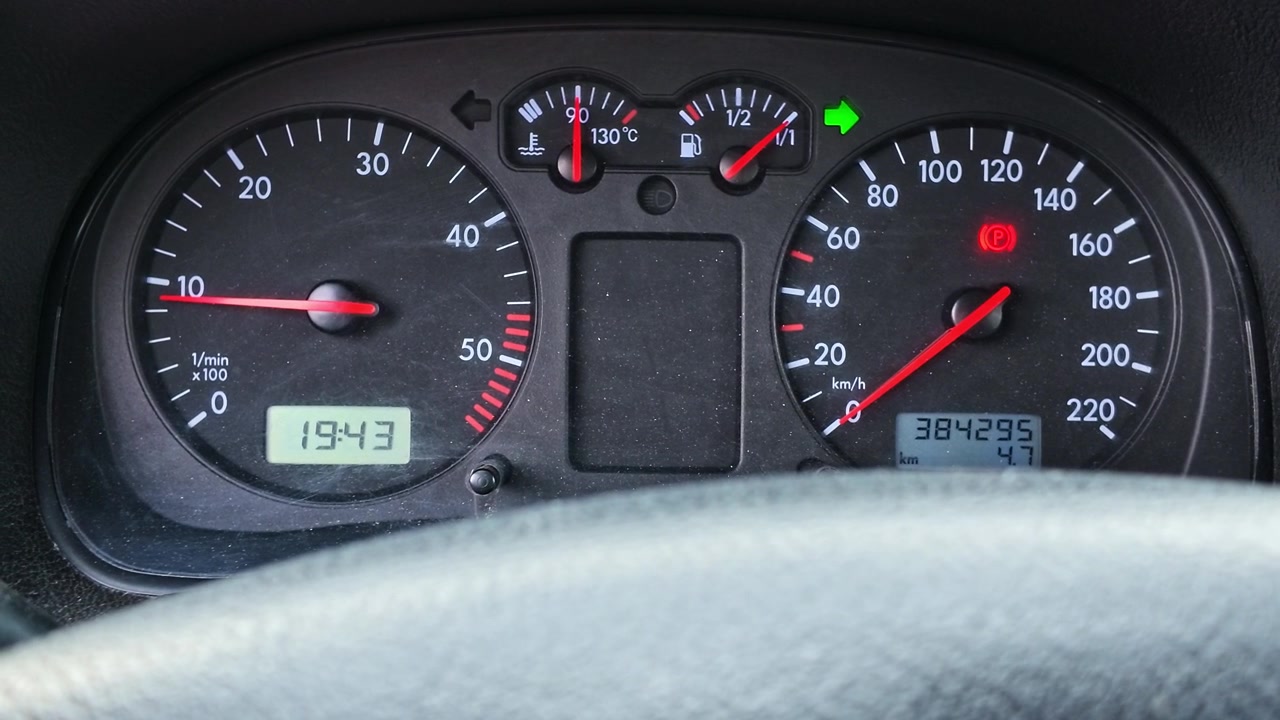 Car's instrument panel with blinking turn signal, showing the tachometer and speedometer needles moving