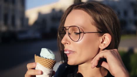 vista lateral de una chica atractiva tomando un gran helado blanco afuera en la calle. mujer joven vestida moderna, transparente