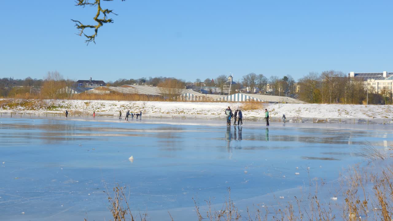 People ice skating on frozen lake in beautiful sunny weather (2)