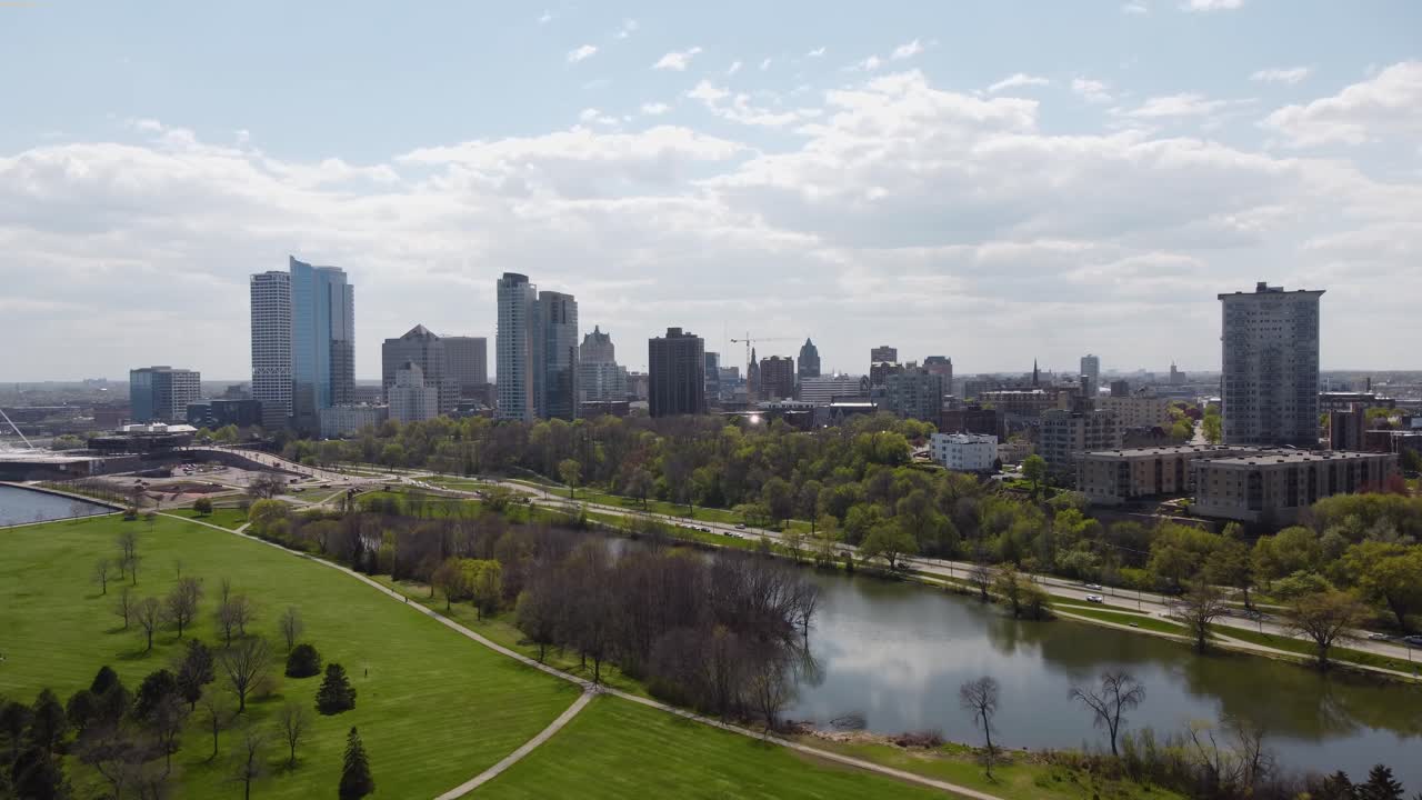 Aerial 4k drone footage of downtown Milwaukee during a summer sunny day overlooking Lake Michigan, park, apartments, lake, and Bradford beach.